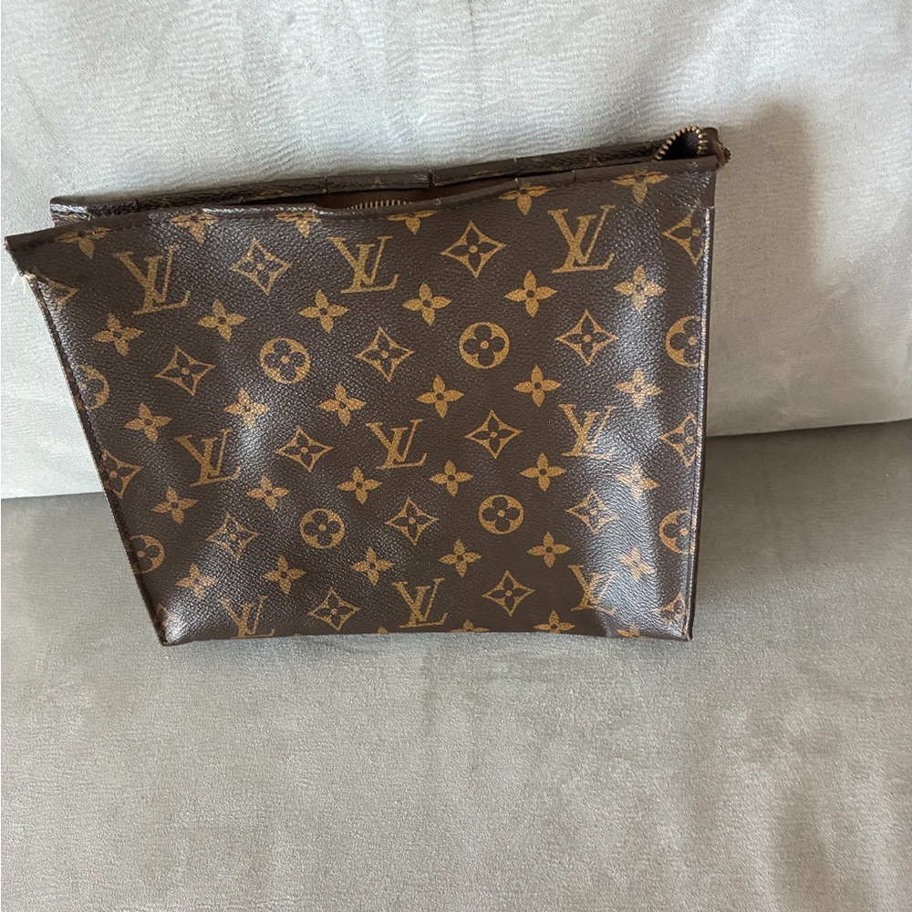 Louis Vuitton cosmetic pouch worn as purse